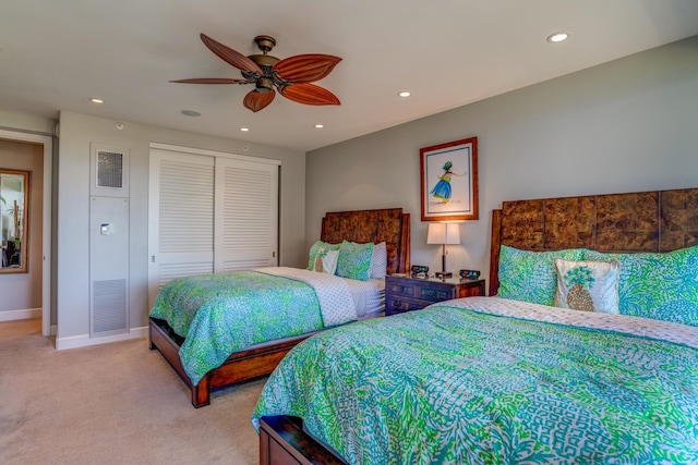 bedroom featuring light carpet, ceiling fan, and a closet