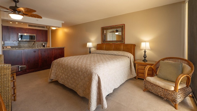 bedroom featuring carpet flooring, ceiling fan, and sink