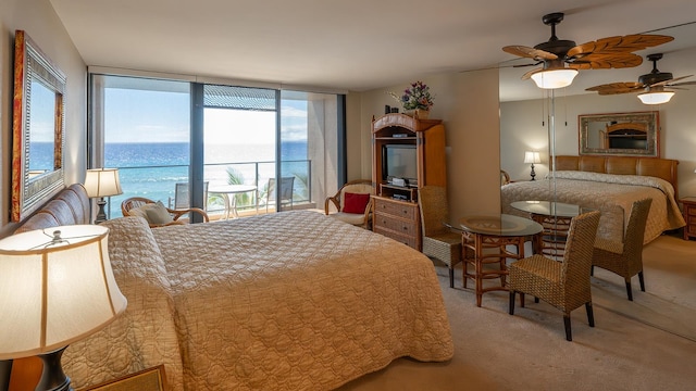 bedroom featuring access to outside, ceiling fan, a water view, and carpet floors