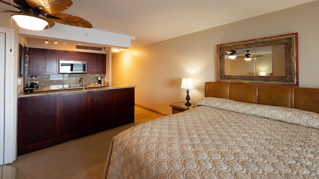 bedroom featuring carpet, ceiling fan, and sink