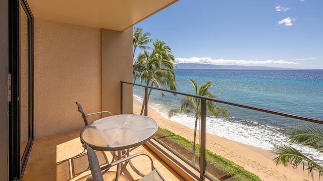 balcony featuring a water view and a beach view