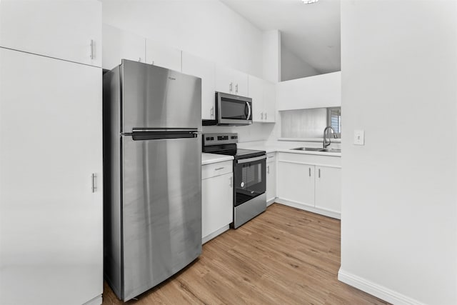 kitchen featuring sink, white cabinetry, high vaulted ceiling, light hardwood / wood-style flooring, and appliances with stainless steel finishes