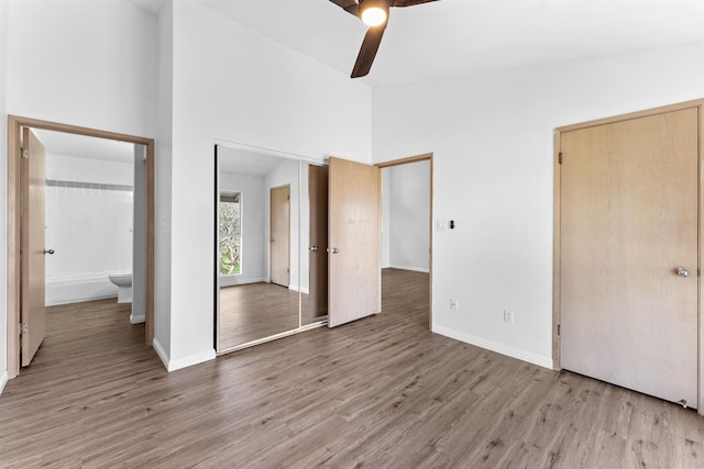 unfurnished bedroom featuring high vaulted ceiling, ceiling fan, and light wood-type flooring