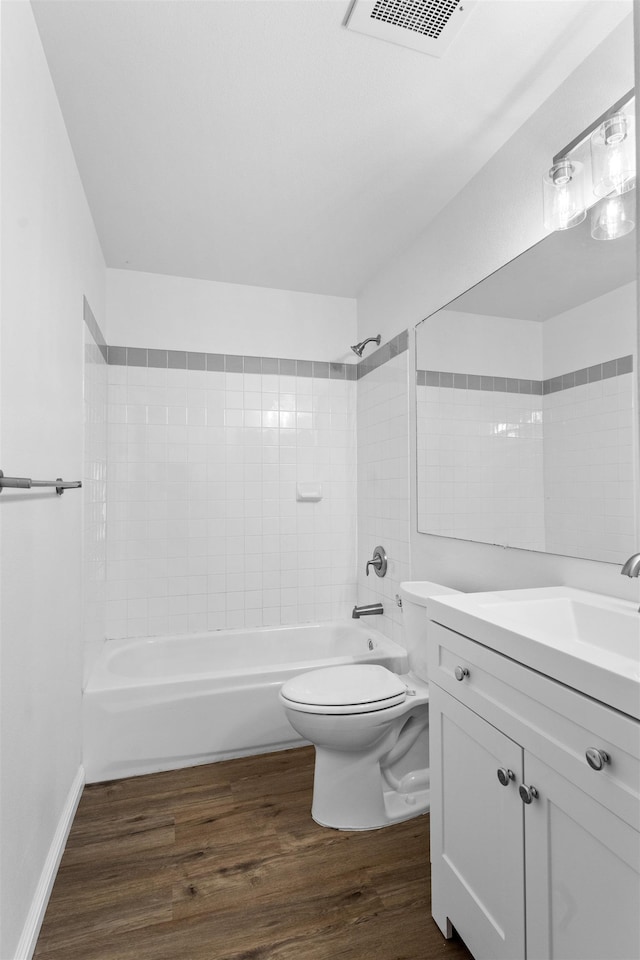 full bathroom featuring hardwood / wood-style flooring, vanity, toilet, and tiled shower / bath combo