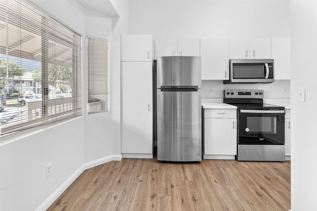 kitchen with white cabinetry, light wood-type flooring, and appliances with stainless steel finishes