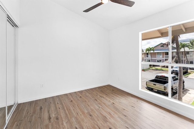 empty room with hardwood / wood-style floors and ceiling fan