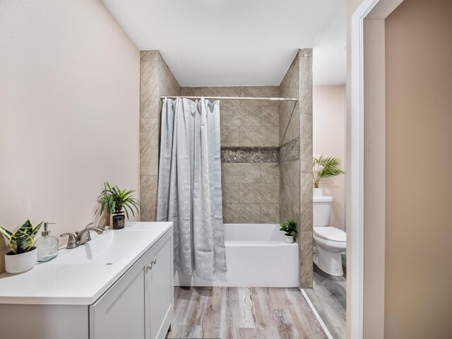 full bathroom featuring wood-type flooring, toilet, vanity, and shower / tub combo