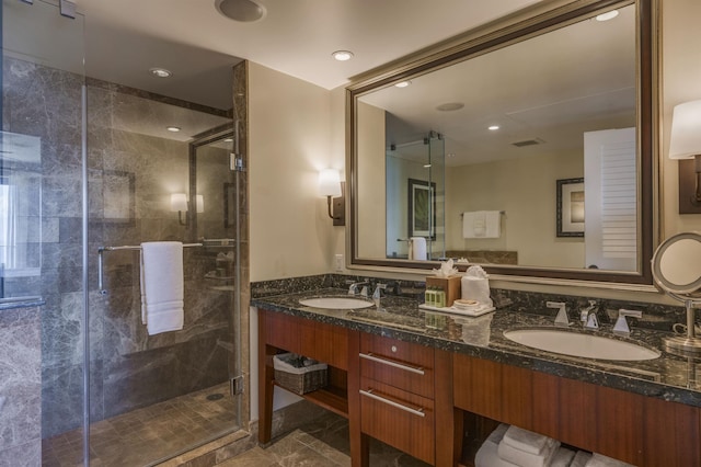 full bathroom featuring double vanity, a shower stall, visible vents, and a sink