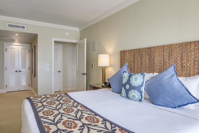 bedroom featuring a closet, light colored carpet, visible vents, ornamental molding, and baseboards