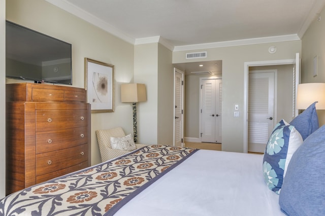 bedroom with baseboards, a closet, visible vents, and crown molding