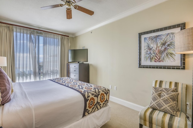 carpeted bedroom featuring ceiling fan, baseboards, and crown molding