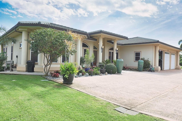 mediterranean / spanish home featuring a garage and a front yard