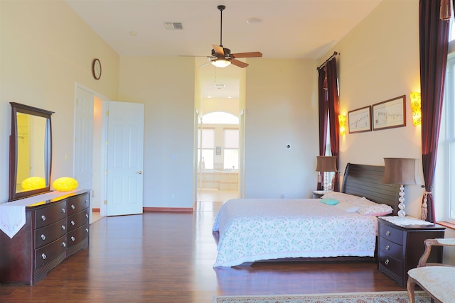 bedroom featuring ensuite bathroom and dark hardwood / wood-style flooring