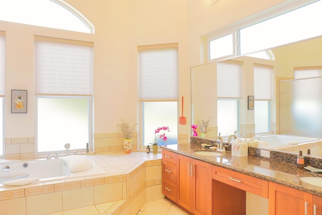 bathroom with vanity, plenty of natural light, and tiled bath