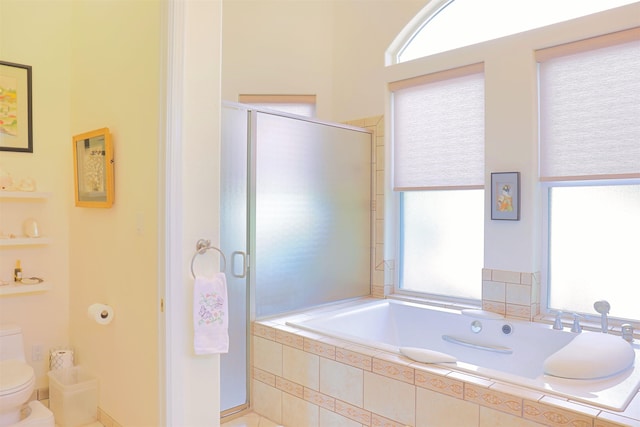 bathroom featuring shower with separate bathtub and toilet