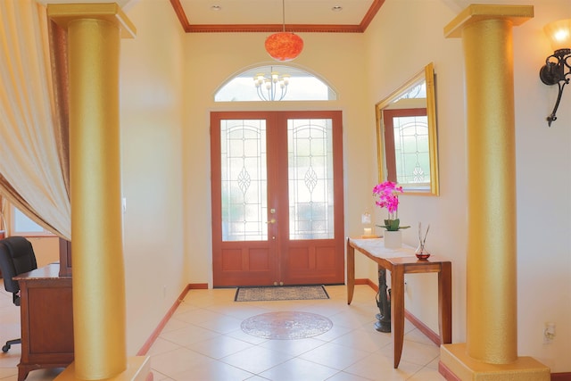 entrance foyer with light tile patterned flooring, ornamental molding, decorative columns, and a notable chandelier