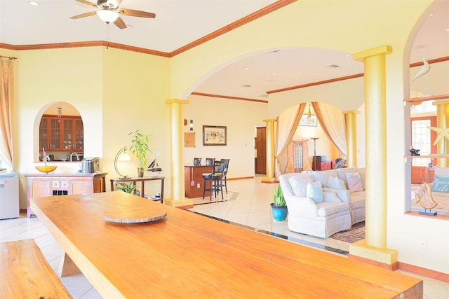 tiled dining space with crown molding and ceiling fan