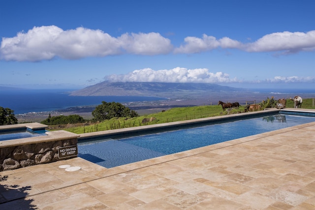 view of pool with an in ground hot tub and a mountain view