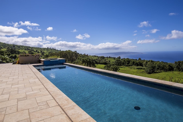 view of swimming pool featuring an in ground hot tub, a water view, and a patio area