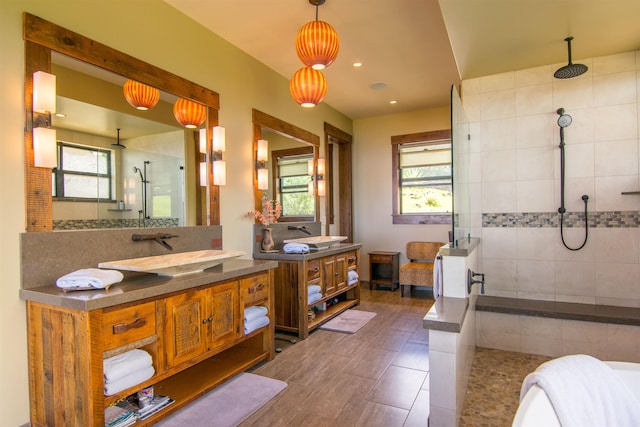 bathroom featuring tiled shower and vanity