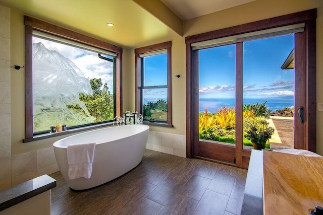 bathroom with a washtub and hardwood / wood-style flooring