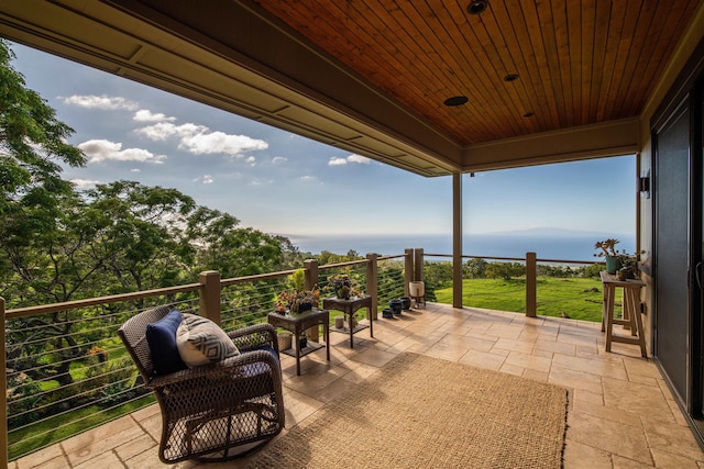 view of patio featuring a balcony and a water view