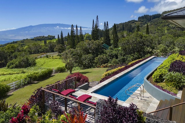 view of swimming pool with a lawn, a patio area, and a mountain view