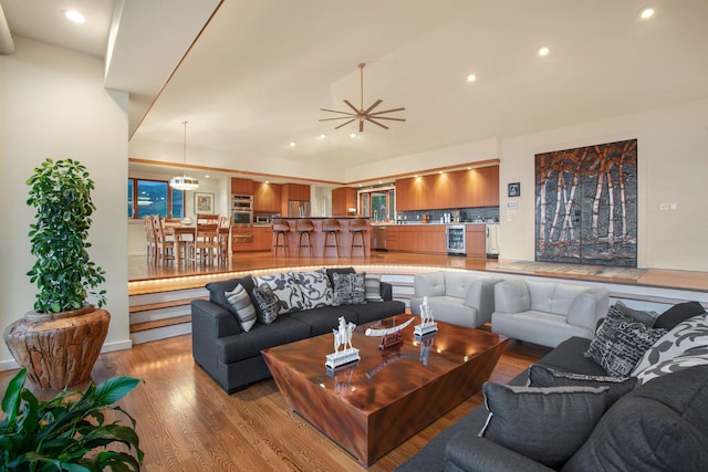 living room featuring light hardwood / wood-style flooring, a notable chandelier, and wine cooler