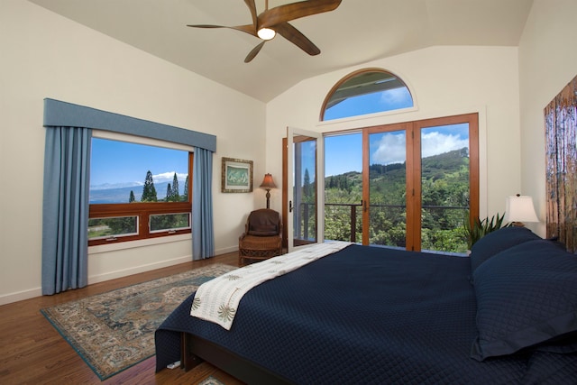 bedroom with ceiling fan, dark hardwood / wood-style floors, a mountain view, and vaulted ceiling