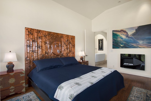 bedroom featuring vaulted ceiling, dark wood-type flooring, and connected bathroom