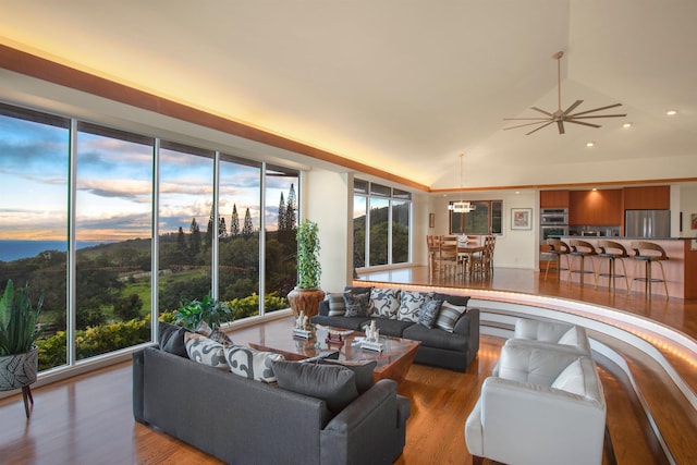 living room with plenty of natural light, hardwood / wood-style floors, and vaulted ceiling