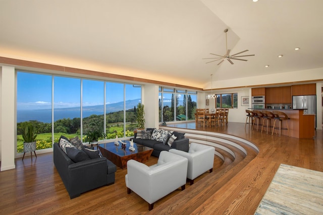 living room with a mountain view, wood-type flooring, lofted ceiling, and ceiling fan