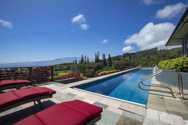 view of swimming pool with a mountain view