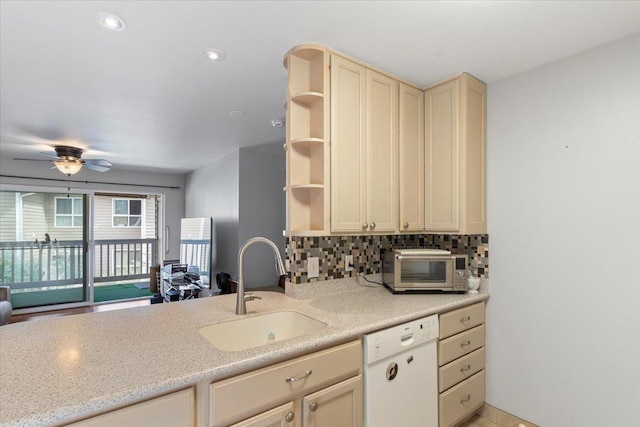 kitchen with sink, dishwasher, ceiling fan, cream cabinets, and decorative backsplash