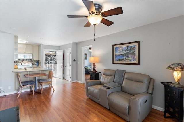 living room featuring ceiling fan and light hardwood / wood-style flooring