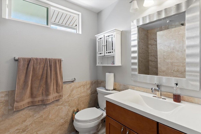 bathroom with vanity, toilet, and tile walls