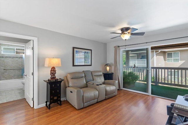 living room featuring ceiling fan and light hardwood / wood-style floors