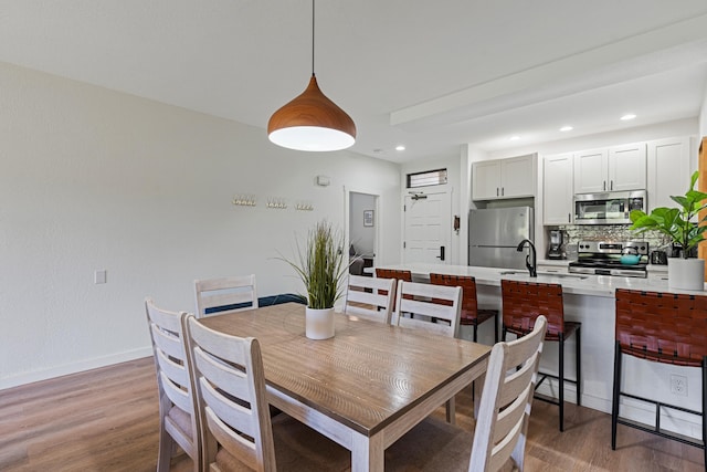 dining room with sink and hardwood / wood-style floors