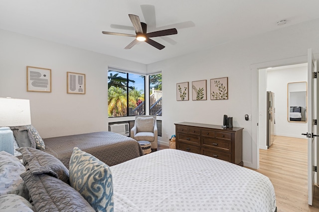 bedroom with light hardwood / wood-style flooring, stainless steel refrigerator, and ceiling fan