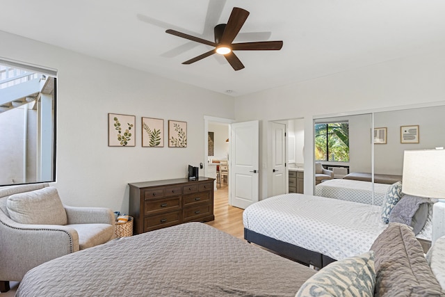 bedroom featuring light wood-type flooring, a closet, ceiling fan, and ensuite bath