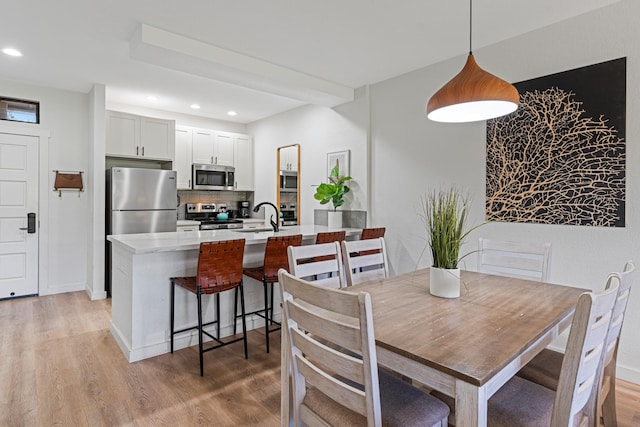 dining room with sink and light hardwood / wood-style floors