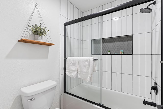 bathroom with toilet and enclosed tub / shower combo