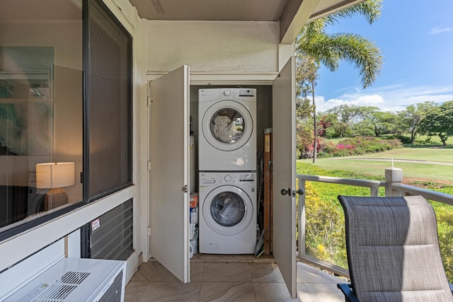 laundry room with a wealth of natural light and stacked washer and clothes dryer