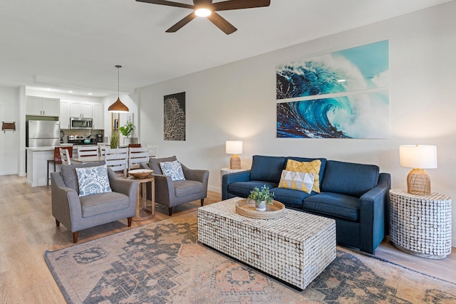 living room featuring light hardwood / wood-style flooring and ceiling fan