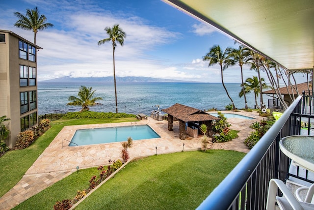 view of pool featuring a yard and a water view