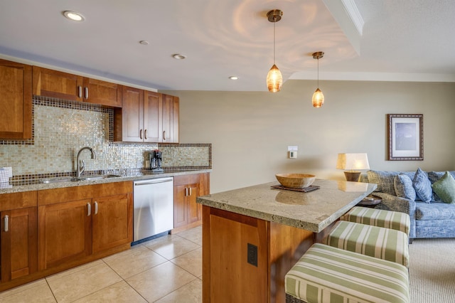 kitchen featuring light stone counters, stainless steel dishwasher, a sink, brown cabinetry, and backsplash