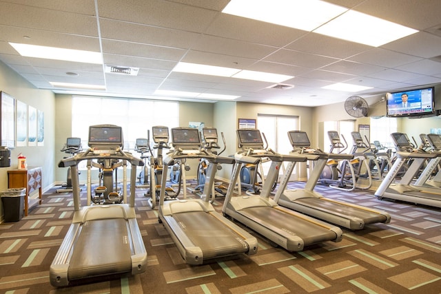 workout area featuring baseboards, visible vents, carpet, and a drop ceiling