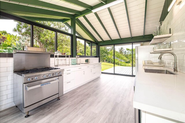 40723 Hana Hwy, Hana, HI 96713 - interior space with high end stainless steel range oven, white cabinetry, vaulted ceiling with beams, light hardwood / wood-style flooring, and sink