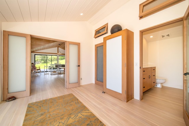 corridor with vaulted ceiling, wooden ceiling, and light hardwood / wood-style floors