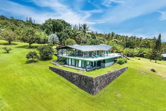 back of property with a wooden deck and a yard